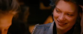Movie still from “Blue Is the Warmest Colour” (2013), directed by Abdellatif Kechiche – A person wearing a jean jacket smiling; Close Up shot, Over the shoulder angle