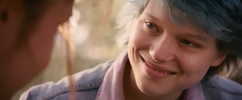 Movie still from “Blue Is the Warmest Colour” (2013), directed by Abdellatif Kechiche – A person smiling; Close Up shot, Over the shoulder angle