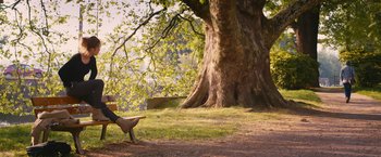 Movie still from “Blue Is the Warmest Colour” (2013), directed by Abdellatif Kechiche – A person sitting under a large tree on the grass; Wide shot, Low angle