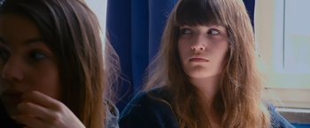 Movie still from “Blue Is the Warmest Colour” (2013), directed by Abdellatif Kechiche – A woman with long brown hair and blue eyes looking at the camera; Close Up shot, Over the shoulder angle