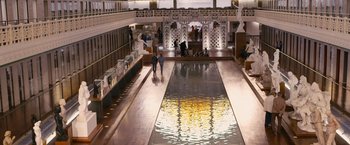 Movie still from “Blue Is the Warmest Colour” (2013), directed by Abdellatif Kechiche – People walk around a large indoor pool in a building; Extreme Wide shot, High angle