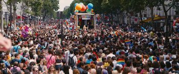 Movie still from “Blue Is the Warmest Colour” (2013), directed by Abdellatif Kechiche – A crowd of people on a city street with balloons; Extreme Wide shot, High angle