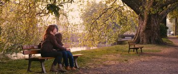 Movie still from “Blue Is the Warmest Colour” (2013), directed by Abdellatif Kechiche – Two people sitting on a park bench near a body of water; Wide shot, Over the shoulder angle