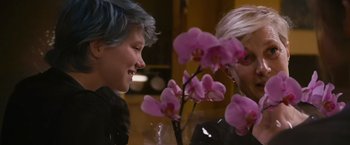 Movie still from “Blue Is the Warmest Colour” (2013), directed by Abdellatif Kechiche – Two women talking to each other in front of some pink flowers; Close Up shot, Over the shoulder angle