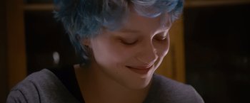 Movie still from “Blue Is the Warmest Colour” (2013), directed by Abdellatif Kechiche – A person with blue hair smiling; Close Up shot, Over the shoulder angle
