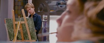 Movie still from “Blue Is the Warmest Colour” (2013), directed by Abdellatif Kechiche – A man standing in front of an easel with an easel in front of him; Medium shot, Low angle