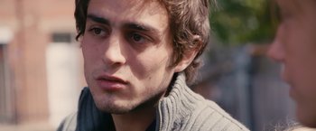 Movie still from “Blue Is the Warmest Colour” (2013), directed by Abdellatif Kechiche – A man's face with a wooded background; Close Up shot, Over the shoulder angle