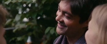 Movie still from “Blue Is the Warmest Colour” (2013), directed by Abdellatif Kechiche – A person with a beard smiling; Close Up shot, Low angle