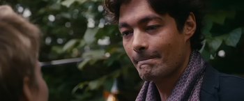 Movie still from “Blue Is the Warmest Colour” (2013), directed by Abdellatif Kechiche – A man's face in a wooded area; Close Up shot, Over the shoulder angle