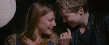 Movie still from “Blue Is the Warmest Colour” (2013), directed by Abdellatif Kechiche – A young man and a young woman smiling at each other; Close Up shot, Over the shoulder angle