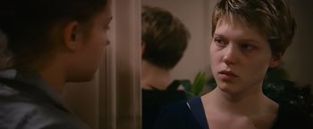 Movie still from “Blue Is the Warmest Colour” (2013), directed by Abdellatif Kechiche – A woman looking into a mirror while another woman looks on; Close Up shot, Over the shoulder angle