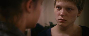 Movie still from “Blue Is the Warmest Colour” (2013), directed by Abdellatif Kechiche – A woman looking into a mirror while another woman looks on; Close Up shot, Over the shoulder angle