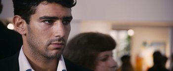 Movie still from “Blue Is the Warmest Colour” (2013), directed by Abdellatif Kechiche – A person wearing a suit and tie; Close Up shot, Over the shoulder angle