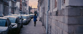 Movie still from “Blue Is the Warmest Colour” (2013), directed by Abdellatif Kechiche – A woman walking down a street near a building; Extreme Wide shot, Low angle