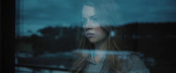 A woman looking out of a car window at night