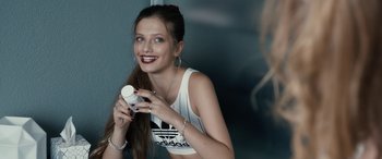 Movie still from “Blue My Mind” (2017), directed by Lisa Brühlmann – A woman holding a bottle of lotion in her hands; Close Up shot, Over the shoulder angle