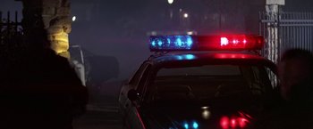 Movie still from “Blue Thunder” (1983), directed by John Badham – A police car with lights turned on at night; Wide shot, Low angle