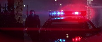 Movie still from “Blue Thunder” (1983), directed by John Badham – A police car with lights on parked on the side of the road; Wide shot, Low angle