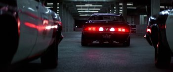 Movie still from “Blue Thunder” (1983), directed by John Badham – A car is parked in a parking garage at night; Wide shot, Low angle