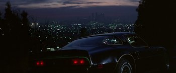Movie still from “Blue Thunder” (1983), directed by John Badham – A car parked on the side of a road at night; Wide shot, Low angle