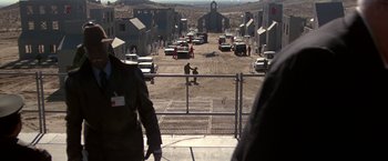 Movie still from “Blue Thunder” (1983), directed by John Badham – A view of a street from a fence; Extreme Wide shot, Over the shoulder angle