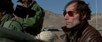 Movie still from “Blue Thunder” (1983), directed by John Badham – A man wearing sunglasses and a jacket holding a glove; Close Up shot, Low angle