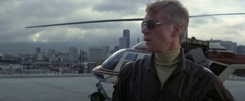 Movie still from “Blue Thunder” (1983), directed by John Badham – A man wearing sunglasses standing in front of a helicopter; Close Up shot, Low angle