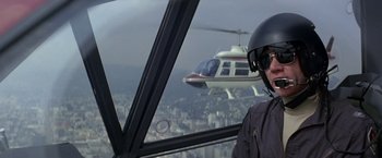 Movie still from “Blue Thunder” (1983), directed by John Badham – A man in a helicopter cockpit looking out a window; Medium shot, Low angle