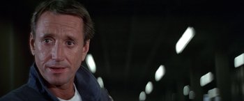 Movie still from “Blue Thunder” (1983), directed by John Badham – A man's face in a dark room; Close Up shot, Low angle