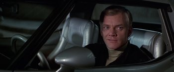 Movie still from “Blue Thunder” (1983), directed by John Badham – A man sitting in the driver's seat of a car; Close Up shot, Low angle