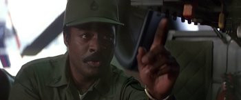 Movie still from “Blue Thunder” (1983), directed by John Badham – A man in a green uniform holding a cell phone; Close Up shot, Low angle