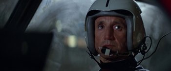 Movie still from “Blue Thunder” (1983), directed by John Badham – A person wearing a motorcycle helmet; Close Up shot, Low angle