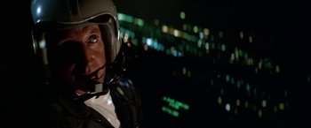 Movie still from “Blue Thunder” (1983), directed by John Badham – A man wearing a motorcycle helmet in the dark; Close Up shot, Low angle