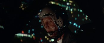 Movie still from “Blue Thunder” (1983), directed by John Badham – A man wearing a helmet is looking into the distance; Close Up shot, Low angle