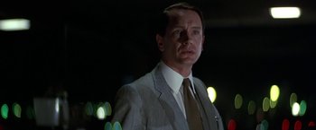 Movie still from “Blue Thunder” (1983), directed by John Badham – A man in a suit and tie standing in the dark; Close Up shot, Low angle