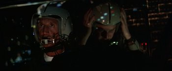 Movie still from “Blue Thunder” (1983), directed by John Badham – Two men in helmets in a dark room; Close Up shot, Overhead angle