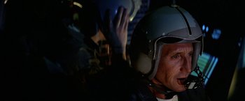 Movie still from “Blue Thunder” (1983), directed by John Badham – A man wearing a helmet in a dark room; Close Up shot, Low angle