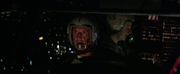 Movie still from “Blue Thunder” (1983), directed by John Badham – A man wearing a helmet in a car at night; Close Up shot, Low angle