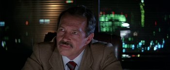 Movie still from “Blue Thunder” (1983), directed by John Badham – An older man wearing a brown suit and a red neck tie; Close Up shot, Low angle