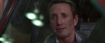 Movie still from “Blue Thunder” (1983), directed by John Badham – A man's face in front of a blurry background; Close Up shot, High angle