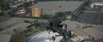 Movie still from “Blue Thunder” (1983), directed by John Badham – A helicopter is flying over a movie set; Extreme Wide shot, High angle