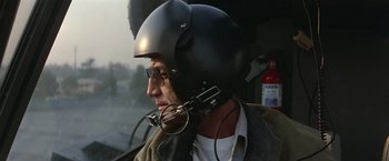 Movie still from “Blue Thunder” (1983), directed by John Badham – A man wearing a helmet while sitting in a helicopter; Close Up shot, Low angle