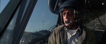 Movie still from “Blue Thunder” (1983), directed by John Badham – An older man wearing a helmet sitting in a helicopter; Close Up shot, Low angle