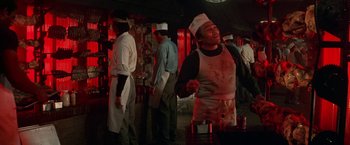 Movie still from “Blue Thunder” (1983), directed by John Badham – A group of people in a room next to a fire hydrant; Medium shot, Low angle