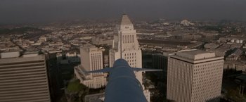 Movie still from “Blue Thunder” (1983), directed by John Badham – An aerial view of a large city with a plane flying over it; Extreme Wide shot, Low angle