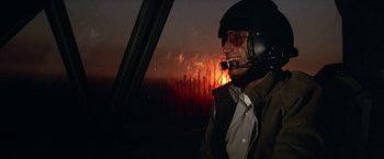 Movie still from “Blue Thunder” (1983), directed by John Badham – A man wearing a helmet while sitting in an airplane; Medium shot, Over the shoulder angle