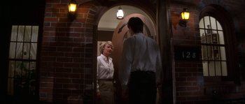 Movie still from “Blue Velvet” (1986), directed by David Lynch – A man and a woman standing in front of an open door; Medium shot, Over the shoulder angle