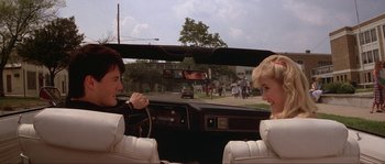 Movie still from “Blue Velvet” (1986), directed by David Lynch – Two people sitting in the back seat of a car; Medium shot, Over the shoulder angle