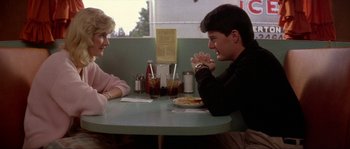 Movie still from “Blue Velvet” (1986), directed by David Lynch – A man and a woman sitting at a table in front of each other; Medium shot, Over the shoulder angle
