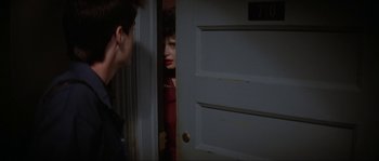 Movie still from “Blue Velvet” (1986), directed by David Lynch – A man and a woman standing in front of an open door; Medium shot, Over the shoulder angle